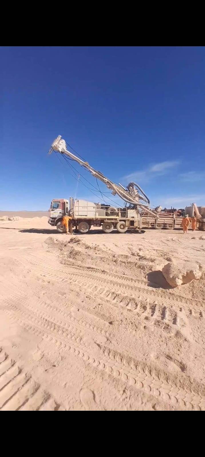 Rig mast being raised during fast site setup in the desert